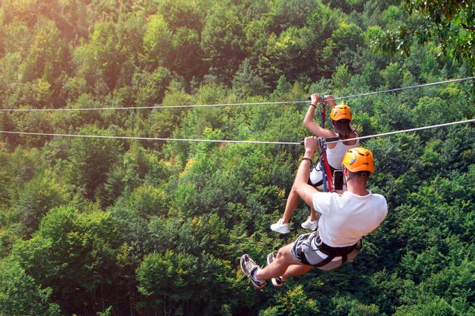 Big Bear Frontier | Big Bear Lake, California | Man and woman ziplining overtop of forest